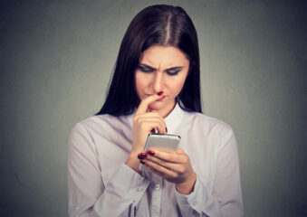 Worried woman watching smartphone