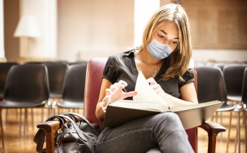 student with face mask in the library